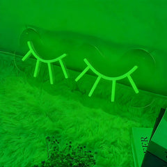 Neon green eyelash-shaped lights on a green background