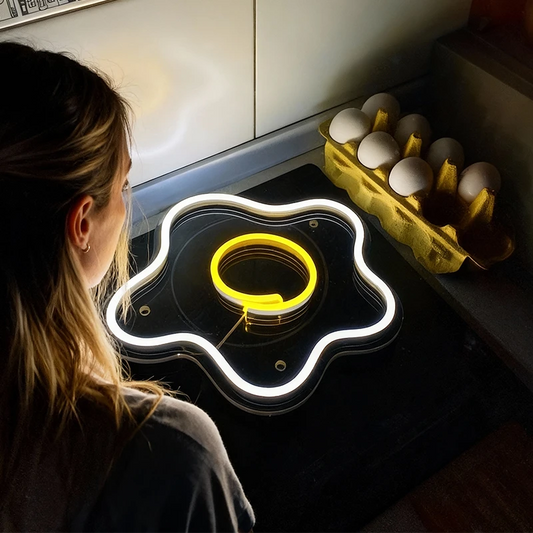 Person looking at a glowing fried egg neon sign on a stove.