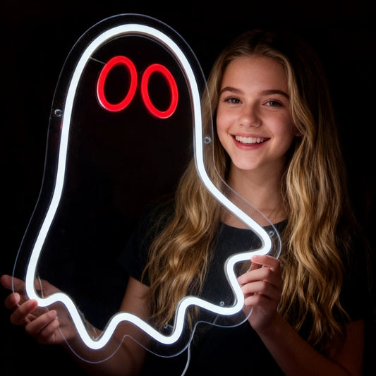Person holding a neon ghost sign with red eyes on a black background