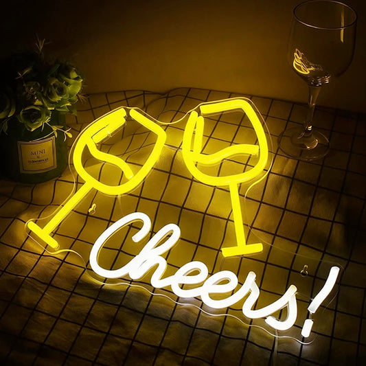 Neon sign with 'Cheers!' and wine glass shapes on a dark surface.