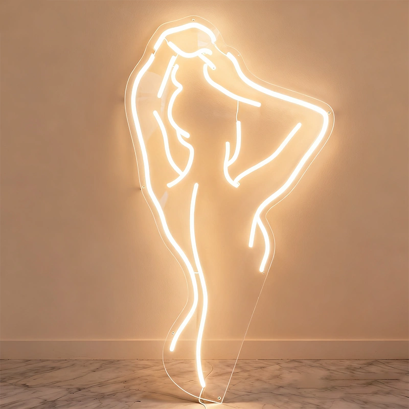 Neon warm white light sculpture of a glowing nude lady on a wall.