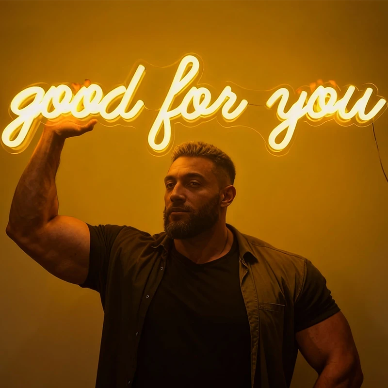 Man flexing his arm with a neon sign saying 'good for you' on a warmwhite background
