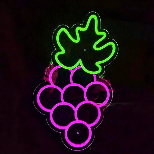 Neon light shaped like grapes with green leaves on a black background