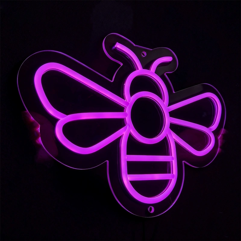 Person holding a purple color honeybee neon sign in a dark background.