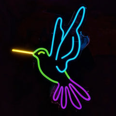 Neon sign of a humming bird with lemon yellow, green, ice blue, and purple colors on a black background