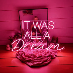 Hot pink neon lighting with 'It was all a dream' text on a wooden surface.