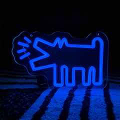 Blue neon sign shaped like a barking dog on a dark background