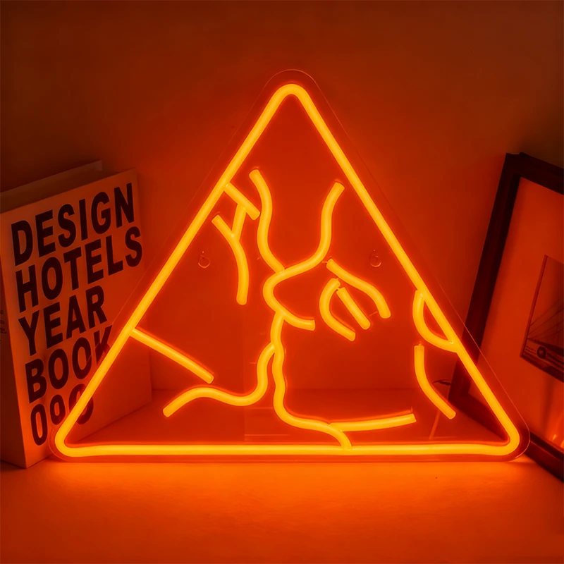 Neon orange sign of a couple kissing in a triangle on a dark background