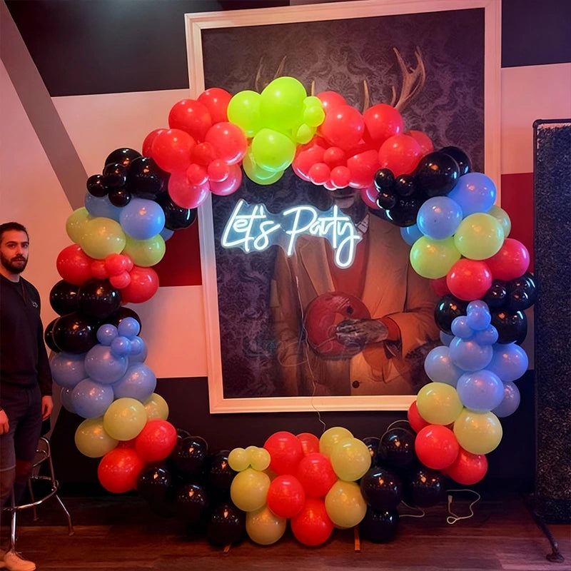 Colorful balloon arch with 'Let's Party' sign in front of a framed picture.