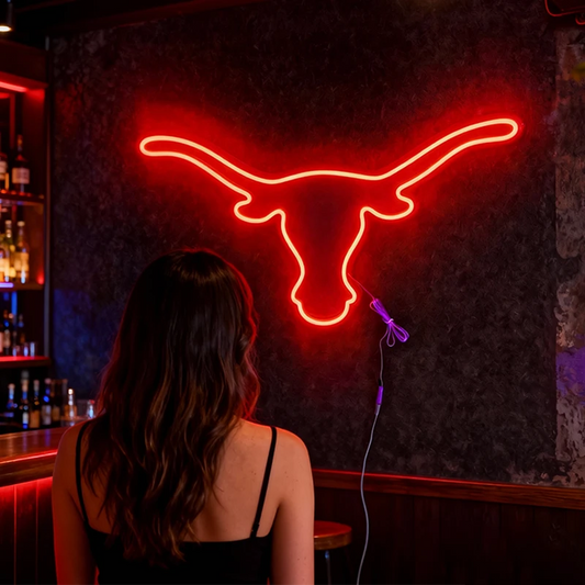 Neon bull head sign in a bar setting with a woman sitting at the bar.