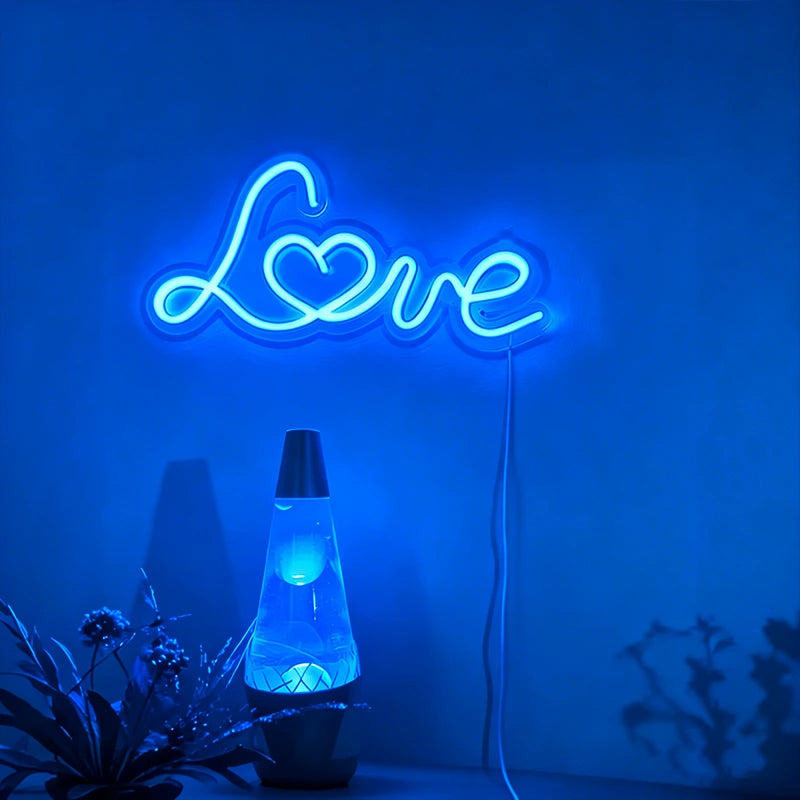Neon sign with 'Love' and a lava lamp on a blue background