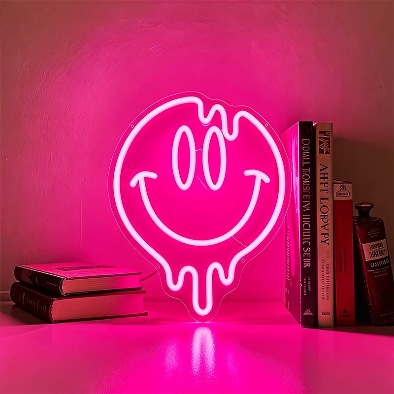 Neon light shaped like a smiley face with a hot pink background