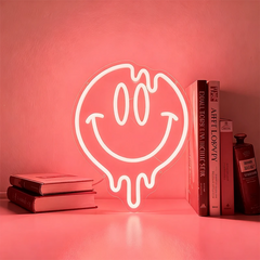 Neon light shaped like a smiley face with a drooling mouth on a light red background.