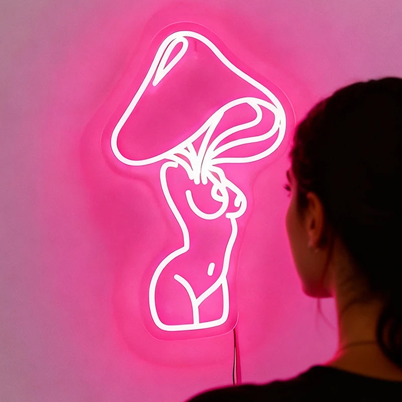 Person looking at a pink neon sign of a woman's silhouette on a dark background