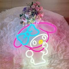 Neon sign of a melody character with a bow on a fluffy pink surface with flowers.
