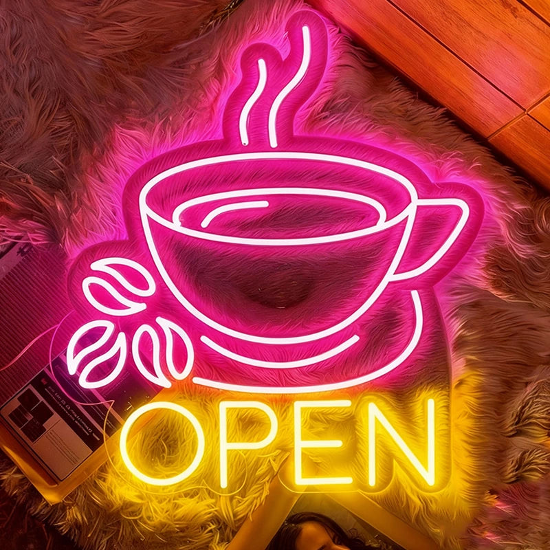 Neon sign of a coffee cup with steam and 'OPEN' text on a fluffy surface.