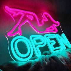 Neon sign with pink woman shape and ice blue 'OPEN' text on a dark background