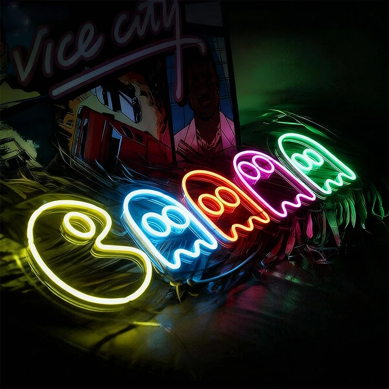 Neon sign with colorful pac-man ghosts on a dark background