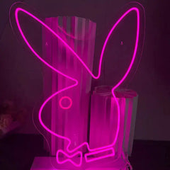 Pink neon sign shaped like a rabbit with bow tie on a dark background