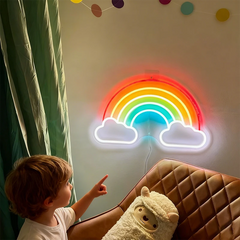 Child pointing at a rainbow-shaped neon light on a wall