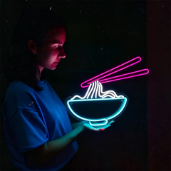 Lady holding a neon sign of a bowl of noodles with chopsticks against a dark background
