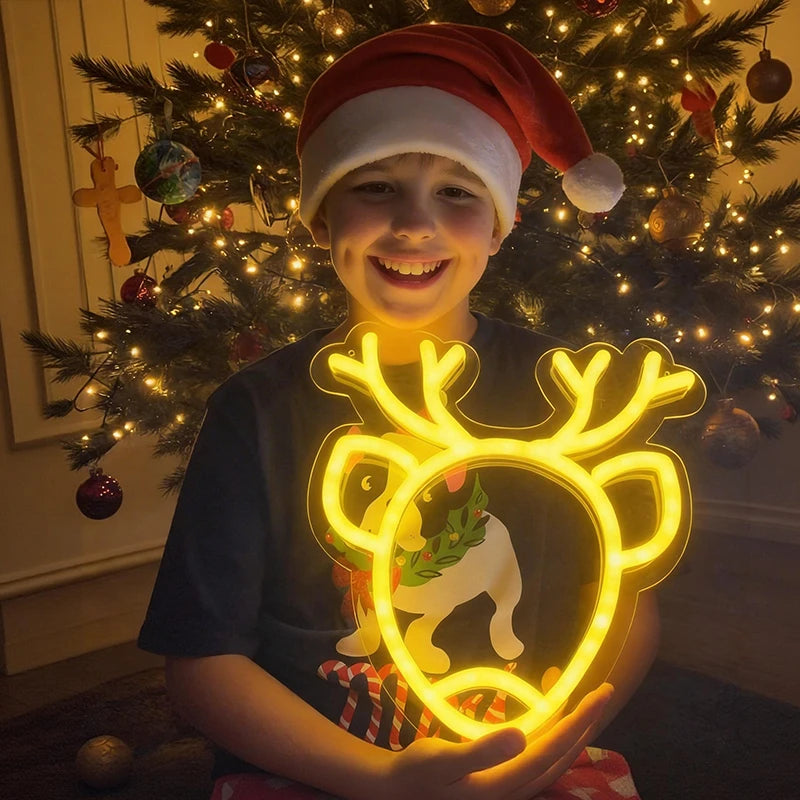 Child holding a glowing reindeer-shaped light in front of a decorated Christmas tree.