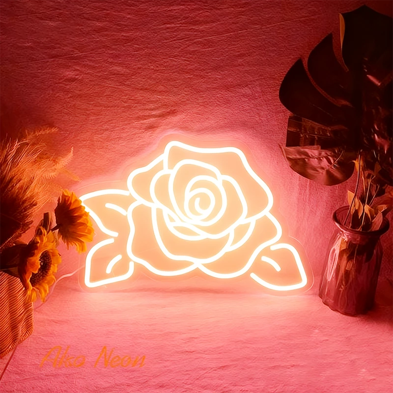 Neon rose warm white light on a pink background with decorative plants.