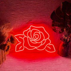 Neon red rose light on a textured wall with decorative elements