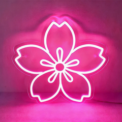 Neon hot pink sakura cherry blossom sign on a dark background.