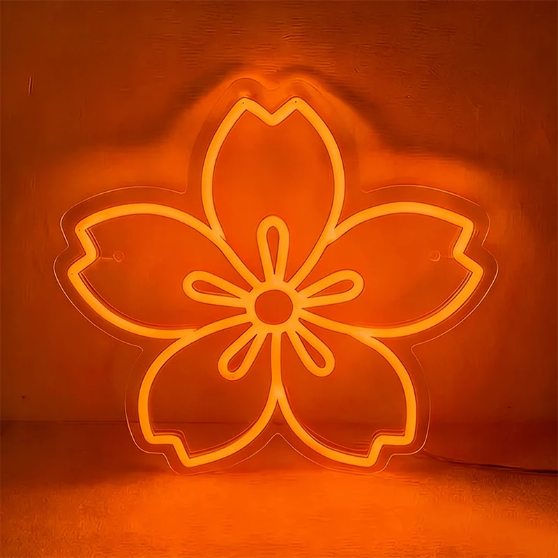 Neon orange sakura cherry blossom sign on a dark background.