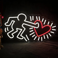 Neon sign with a figure holding a heart on a dark background