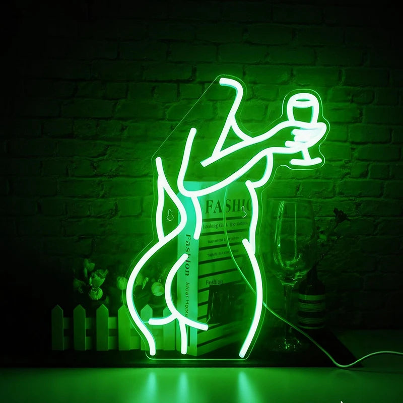 Neon green light of a lady's back holding a glass against a brick wall.