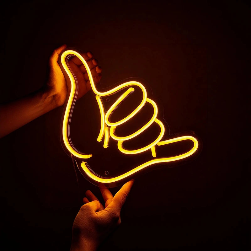 Neon sign shaped like a hand giving a thumbs up on a dark background