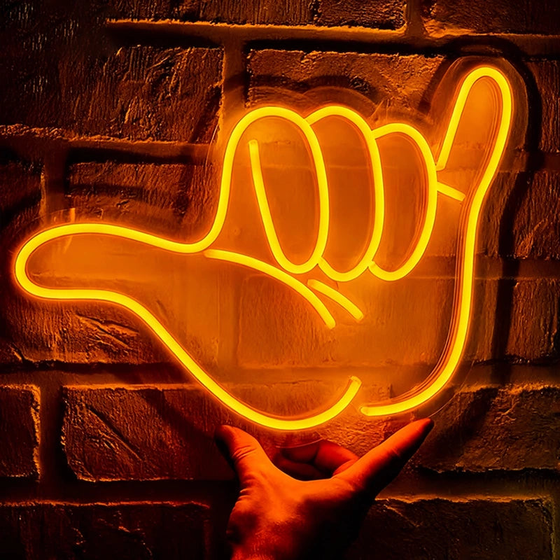 Neon sign shaped like a hand gesture on a brick wall