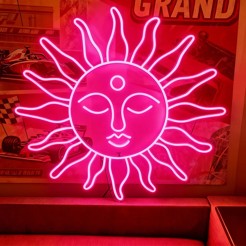 Neon hot pink sun-shaped sign with face design on a red background
