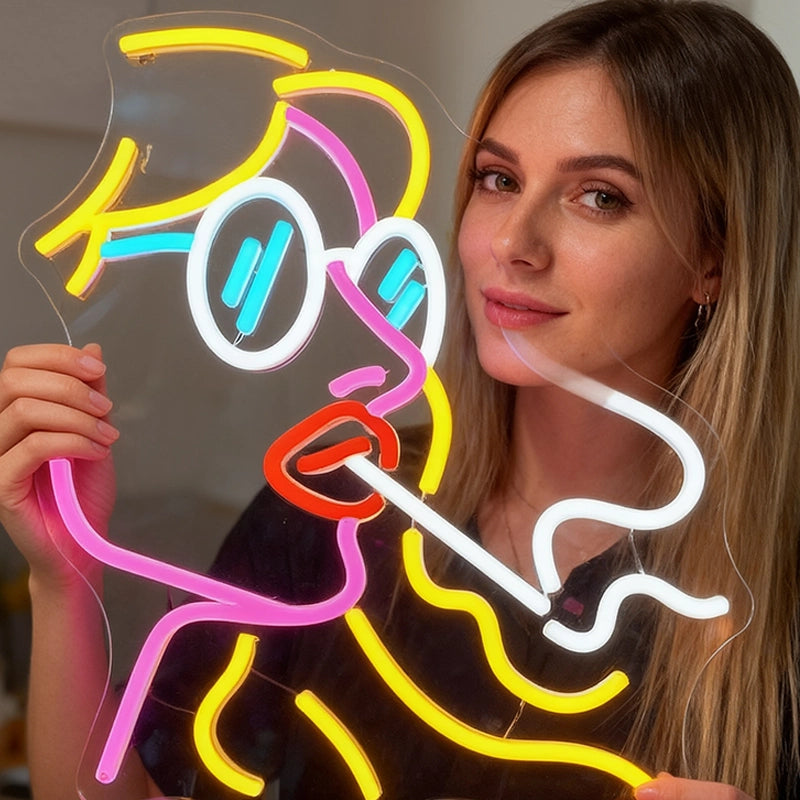 Woman holding a colorful neon sign shaped like a cartoon character.