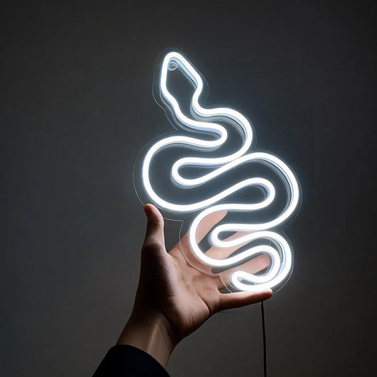 Neon white light shaped like a snake held in a hand against a dark background