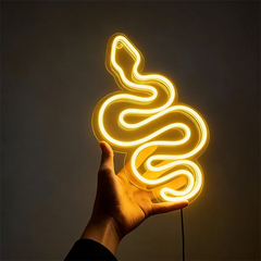 Neon lemon yellow light shaped like a snake held in a hand against a dark background