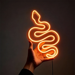 Neon orange light shaped like a snake held in a hand against a dark background