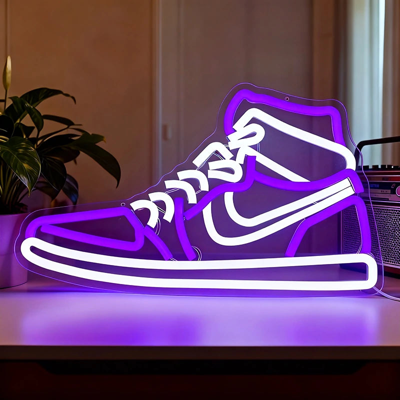 Neon sign shaped like a high-top sneaker on a table with a plant and radio in the background.