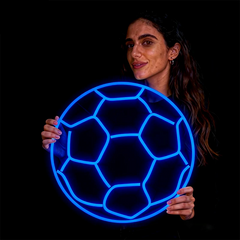 Woman holding a glowing blue soccer ball against a black background