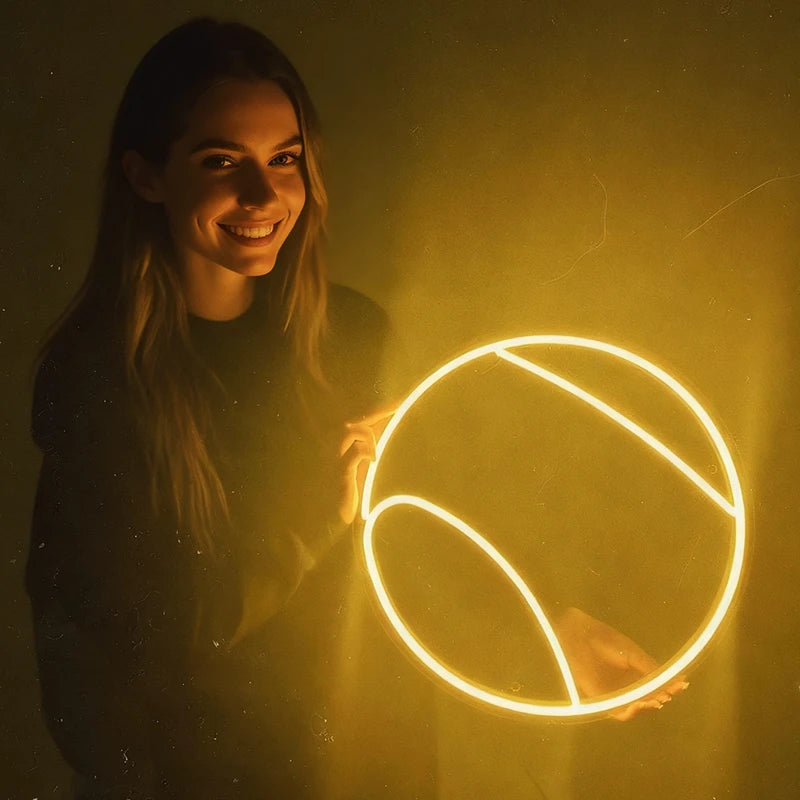 Woman holding a glowing lemon yellow neon tennis ball against a drak background