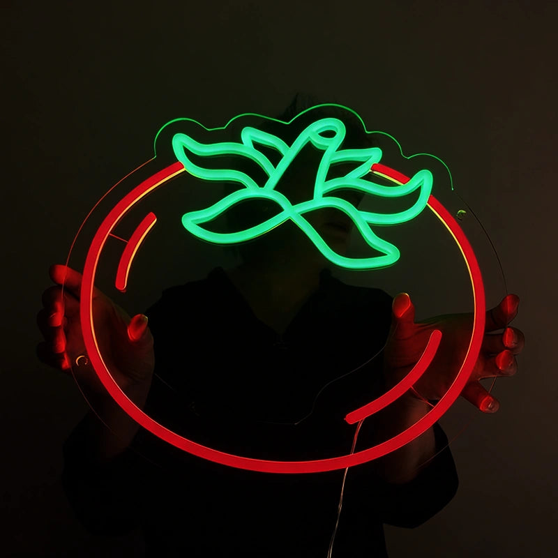 Person holding a tomato neon sign in a dark background with green and red color