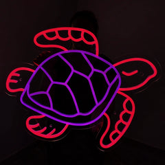 A glowing neon-style turtle sign with a purple shell outline and red outer body and flippers, shown against a dark background.
