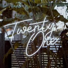 Neon sign with 'Twenty One' on a textured background