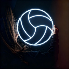 Person holding a neon light shaped like a volleyball in a dark setting