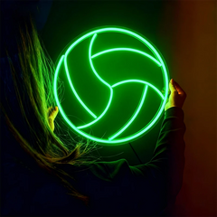 Person holding a glowing green volleyball against a dark background