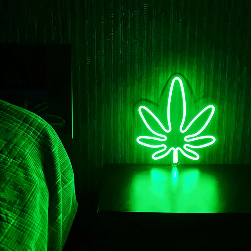 Green weed neon sign in a dark background.
