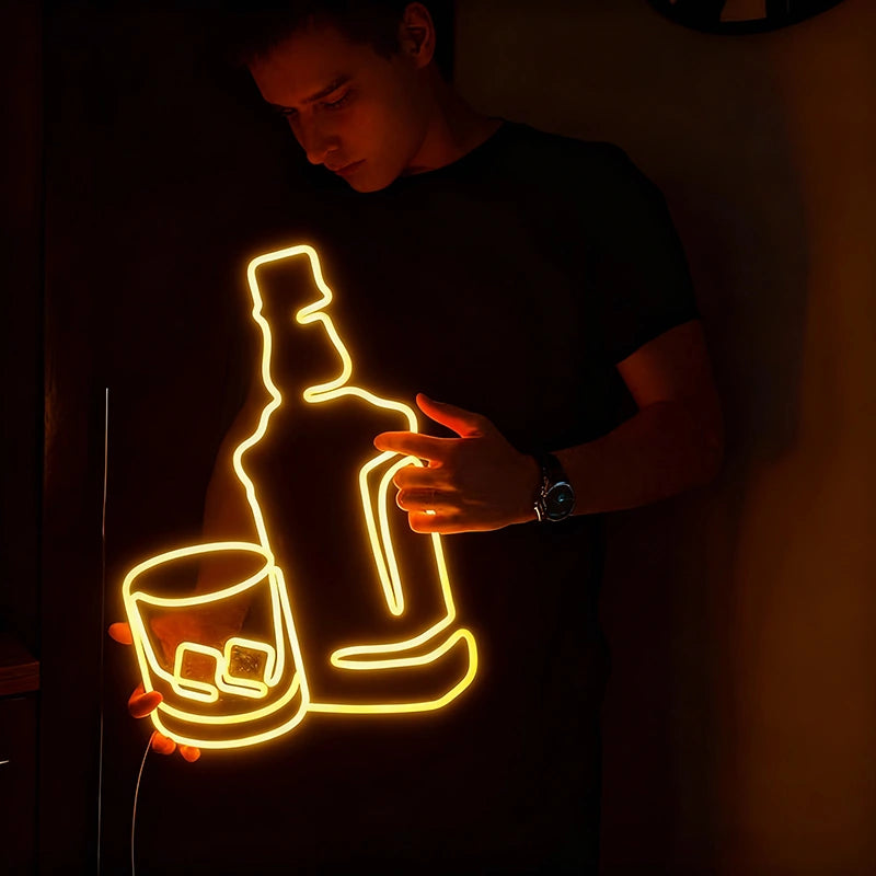Neon light sculpture of a bottle and glass in a dark setting