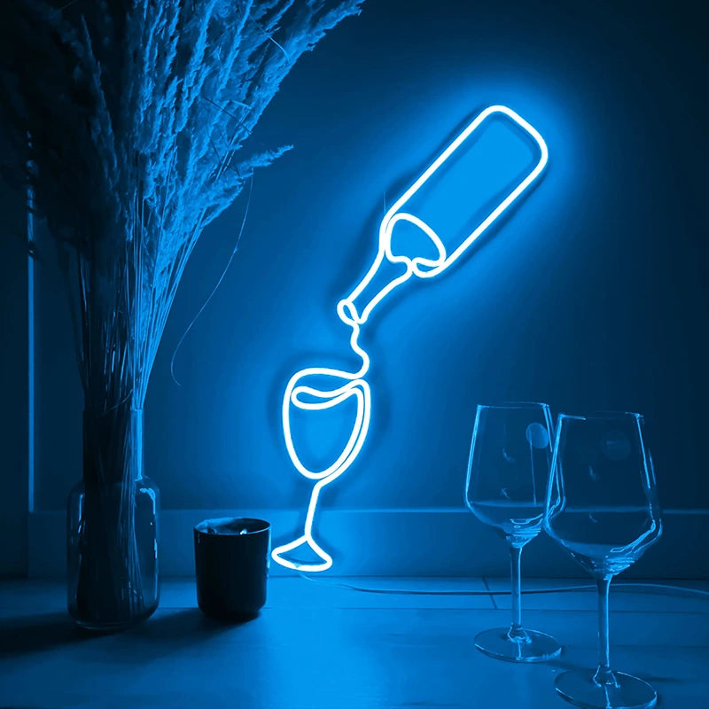 Neon ice blue light sculpture of a wine bottle and glasses on a dark background